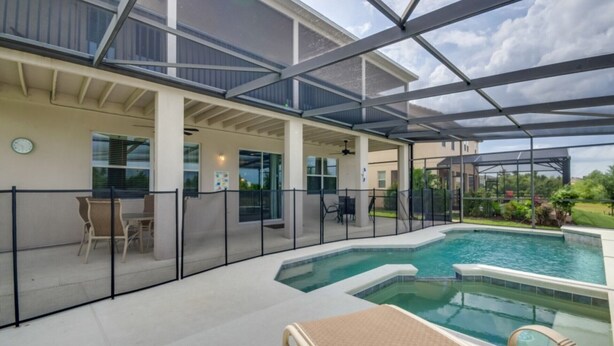 A covered outdoor swimming pool area with lounge chairs and a patio table. - 5 Star Villa on West Haven With First Class Amenities, Orlando Villa 1825 (Davenport)