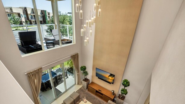 A spacious living area with a large window, a flat-screen TV, and a comfortable seating arrangement. - 5star Villa Close to Disney, Orlando Townhome 3701 (Kissimmee)