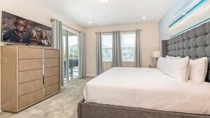 A hotel room with a large bed, a wardrobe, a television, and a view of the outside through the windows.