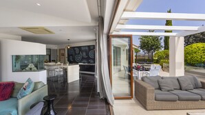 A modern living room with a sofa, a dining area, and a kitchen. - At Last You can Rent the Perfect Luxury Villa in Protaras Close to all the Action, Protaras Villa 1569 (Paralimni)