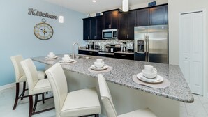 A modern kitchen with dark cabinets, stainless steel appliances, and a granite countertop. - Beautiful 5 Star Townhome on Storey Lake Resort With Private Pool, Orlando Townhome 4889 (Kissimmee)