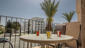 A round table with four cups on a balcony overlooking a cityscape. - Beautiful Apartment With Communal Pool, Ayia Napa Apartment 1282 (Ayia Napa)