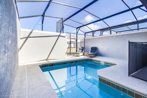 Ein Innenpool mit Glasdach, einer Lounge mit Sesseln und Blick zum Himmel.