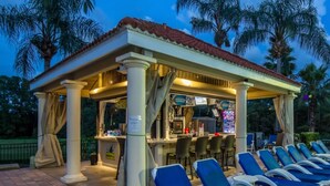 A covered outdoor seating area with lounge chairs and a bar. - 5star Villas Close to Disney Orlando Townhome 3145 (Kissimmee)