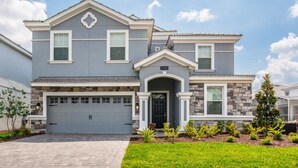 A two-story house with a garage, a stone facade, and a well-maintained lawn. - The Ultimate Guide to Renting Your 5 Star Villa on Champions Gate Resort, Orlando Mansion 1817 (Davenport)