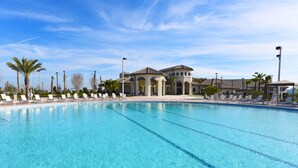 A large swimming pool with clear blue water, surrounded by lounge chairs and palm trees. - At Last You can Rent the Perfect Luxury Mansion on Champions Gate Resort, Minutes From Disney World, Orlando Mansion 3117 (Davenport)
