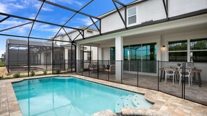 A swimming pool with a glass enclosure, patio furniture, and a covered seating area. - Beautiful Mansion With Private Pool, Close to Disney, Orlando Mansion 3113 (Kissimmee)