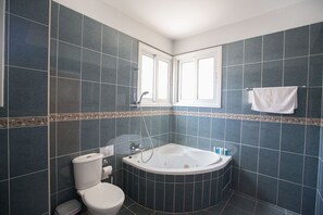 A bathroom with dark blue tiles, a toilet, a bathtub, and a window. - Beautiful Villa With Private Pool, Protaras Villa 1268 (Paralimni)