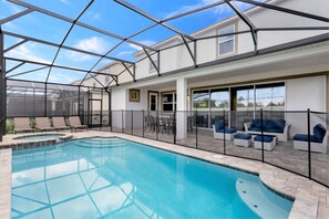 A swimming pool with a glass ceiling, outdoor seating, and a patio area.