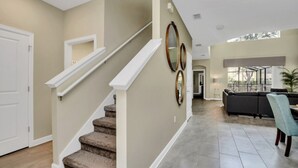A spacious living area with a staircase, a dining area, and a view of the outdoors. - Luxury 5 Star Villa on Storey Lake Resort,minutes From Disney World, Orlando Villa 3654 (Kissimmee)