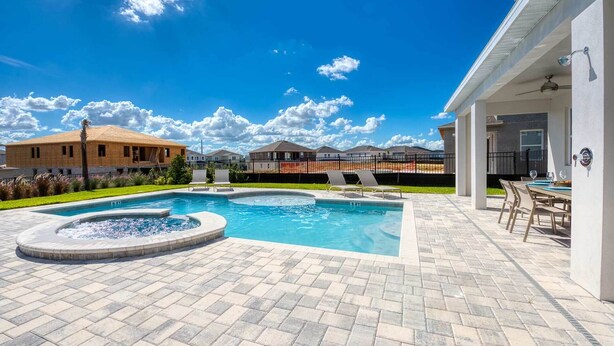 A swimming pool with a hot tub, surrounded by a patio area with outdoor seating. - Beautiful Villa With First Class Amenities on Encore Resort at Reunion, Orlando Villa 4708 (Kissimmee)