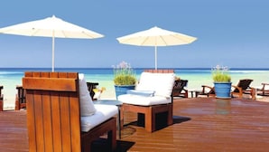 A wooden deck with lounge chairs and umbrellas overlooking a beach. - Cyprus Villa Minutes From the Beach, Sotira Villa 1299 (Sotira)