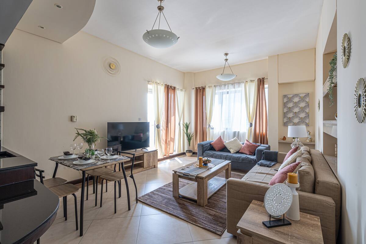 Appartamento Deluxe | Area soggiorno | TV a schermo piatto 55 pollici con canali via cavo, TV