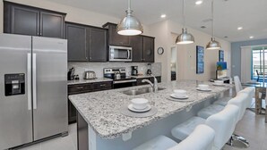 A modern kitchen with granite countertops, stainless steel appliances, and pendant lighting. - Tranquil Oasis With Lush Gardens 5496 (Davenport)