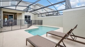 A swimming pool with lounge chairs, a covered patio, and a view of neighboring buildings. - Imagine You and Your Family Renting This 5 Star Villa on Storey Lake Resort , Orlando Townhome 5519 (Kissimmee)