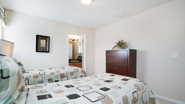 A bedroom with two beds, a dresser, a mirror, and a ceiling light. - Imagine You and Your Family Renting This 5 Star Villa on Providence Resort, Orlando Villa 3629 (Davenport)