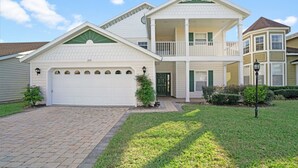A two-story house with a garage, a balcony, and a well-maintained lawn. - Imagine You and Your Family Renting This 5 Star Villa on Providence Resort, Orlando Villa 3629 (Davenport)