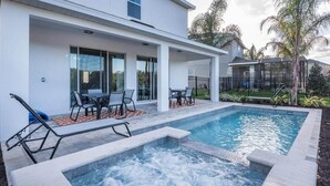 A modern outdoor pool area with a hot tub, lounge chairs, and a covered patio with tables and chairs. - Luxury Villa With Private Pool on Encore Resort at Reunion, Orlando Villa 4695 (Kissimmee)