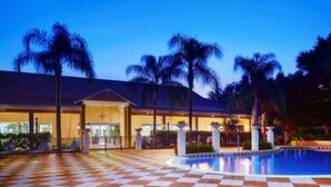 A hotel with a pool, palm trees, and a checkered floor. - Perfect Townhome on Enchantada Resort Orlando Townhome 5495 (Kissimmee)