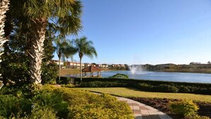 A landscaped area with a gazebo, a fountain, and a body of water. - Perfect Townhome on Enchantada Resort Orlando Townhome 5495 (Kissimmee)