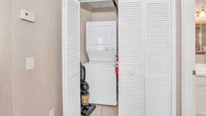 A laundry room with a white washer and dryer, a fire extinguisher, and a water heater. - Luxury Home on Bahama Bay Resort,minutes From Disney World, Orlando Condo 5057 (Davenport)