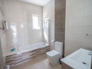 A modern bathroom with a bathtub, toilet, and sink. - Luxury 5 Bedroom Villa With Private Pool, Protaras Villa 1250 (Paralimni)