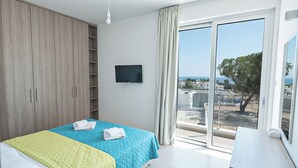 A bedroom with a bed, a wardrobe, a TV, and a view of the outside. - Luxury 5 Bedroom Villa With Private Pool, Protaras Villa 1250 (Paralimni)