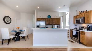 A modern kitchen with wooden cabinets, a central island, and stainless steel appliances. - Luxury 5 Bed Villa, Perfect for Large Groups, 1005 (Davenport)