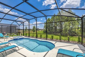 A covered outdoor swimming pool with lounge chairs and a view of a forested area. - Perfect Holiday Villa on Solterra Resort Orlando Villa 5493 (Davenport)