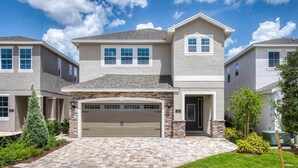 A two-story house with a stone facade, a garage, and a well-maintained lawn.