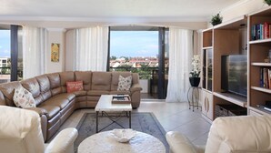 A modern living room with a leather sectional sofa, a coffee table, and a bookshelf. - Perfect Apartment on The Anchorage, Siesta Key Apartment 1022 (Siesta Key)