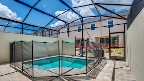En utomhuspool med tak, med utsikt över en bostadsbyggnad i bakgrunden.