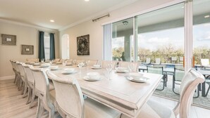 Een eetgedeelte met een lange tafel gedekt voor zes personen, omringd door stoelen.