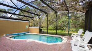 An outdoor swimming pool with a covered area, surrounded by brick flooring and white lounge chairs. - Rent a Luxury Villa on Encantada Resort, Minutes From Disney, Orlando Villa 1062 (Kissimmee)