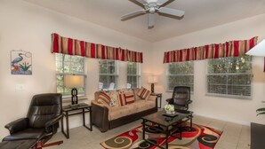 A living room with a beige sofa, two black leather chairs, a coffee table, and a patterned rug. - Rent a Luxury Villa on Encantada Resort, Minutes From Disney, Orlando Villa 1062 (Kissimmee)