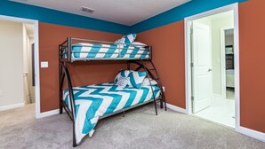 A bunk bed room with a chevron-patterned bedspread, a door to a closet, and a carpeted floor. - Rent a Luxury Villa on Champions Gate Resort, Minutes From Disney, Orlando Villa 1437 (Davenport)