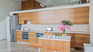 Una cocina moderna con armarios de madera, electrodomésticos de acero inoxidable y una isla central con asientos.