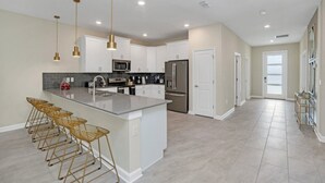 A modern kitchen with a central island, stainless steel appliances, and pendant lighting. - Picture Renting Your Own Luxury Mansion on the Exclusive Storey Lake Resort, Close to Disney, Orlando Mansion 5043 (Kissimmee)