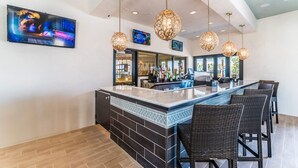 A bar area with a counter, bar stools, and hanging pendant lights. - Luxe Contemporary Style Villa, Orlando Villa 4909 (Kissimmee)