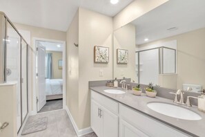 A modern bathroom with two sinks, a large mirror, and a shower area. - At Last You can Rent the Perfect Luxury Mansion on Storey Lake Resort, Minutes From Disney World, Orlando Mansion 5040 (Kissimmee)