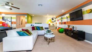 Ein modernes Wohnzimmer mit einem weißen Sofa, bunten Kissen, einem Couchtisch und einer TV-Wand.