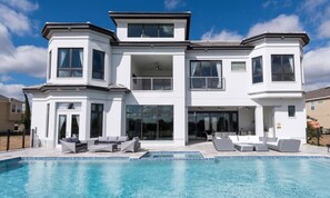 A modern two-story house with a swimming pool, large windows, and a balcony. - Rent This Luxury 5 Star Villa on Reunion Resort and Spa, Orlando Mansion 4573 (Kissimmee)