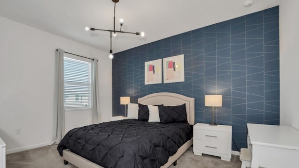 Une chambre à coucher avec un lit, des tables de chevet, un bureau et une chaise.