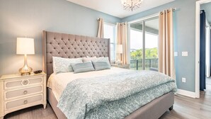 A bedroom with a tufted headboard, a bedside table with a lamp, and a large bed with patterned bedding. - Ultimate 5 Star Villa With Private Pool on Encore Resort at Reunion, Orlando Villa 4391 (Kissimmee)