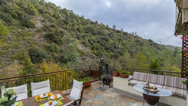 A terrace with a table set for breakfast, a sofa, and a stone floor. - You and Your Family Will Love This Villa Close to the Beautiful Town of Limassol, Limassol Villa 1003 (Kato Amiantos)