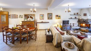 A cozy living room with a fireplace, wooden furniture, and a dining area. - You and Your Family Will Love This Villa Close to the Beautiful Town of Limassol, Limassol Villa 1003 (Kato Amiantos)
