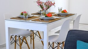 A dining table set with plates, cutlery, and a vase of flowers. - The Perfect Holiday Apartment Minutes From the Beach in Larnaca, Larnaca Apartment 1401 (Larnaca)