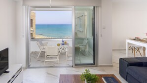A modern living room with a balcony overlooking a beach. - The Perfect Holiday Apartment Minutes From the Beach in Larnaca, Larnaca Apartment 1401 (Larnaca)