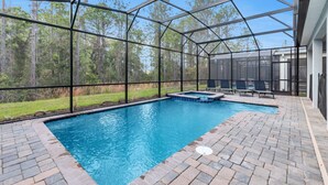 A covered outdoor swimming pool with a hot tub, surrounded by a metal fence and brick flooring. - Your Beautiful 5 Star Villa Minutes From Disney on the Prestigious Storey Lake Resort, Orlando Villa 3653 (Kissimmee)