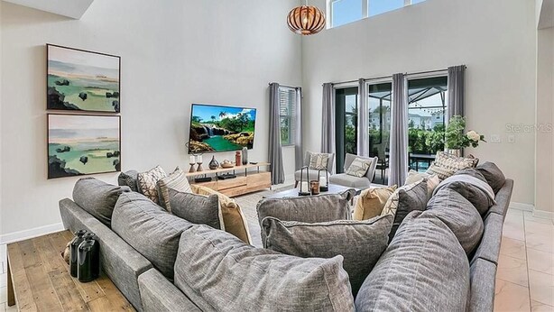 A spacious living room with a large sofa set, a flat-screen TV, and artwork on the walls. - You Will Love This 5 Star Villa Located on Storey Lake Resort, Orlando Villa 5492 (Kissimmee)
